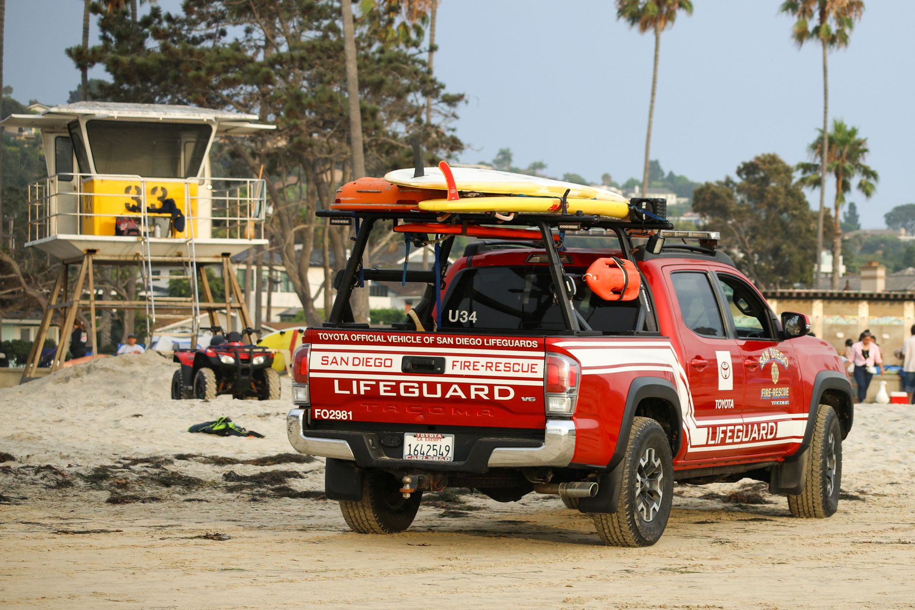 a red truck with a surfboard on top of it